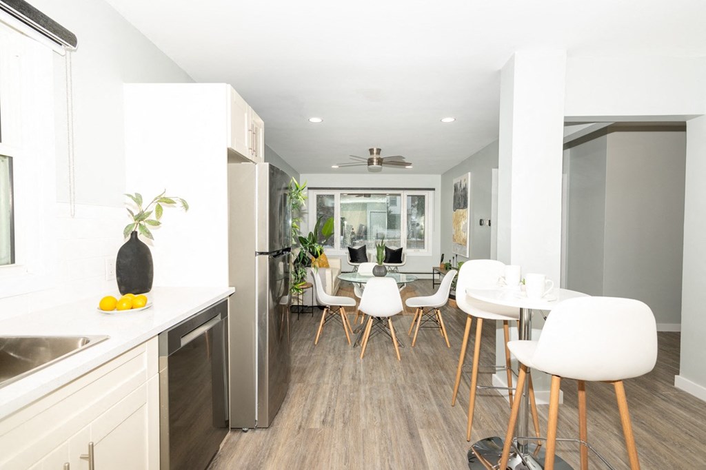 A kitchen with a dining table and chairs.