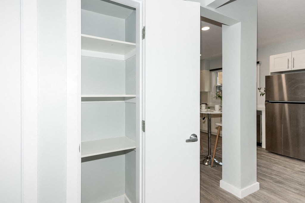 A white door is open to a kitchen.