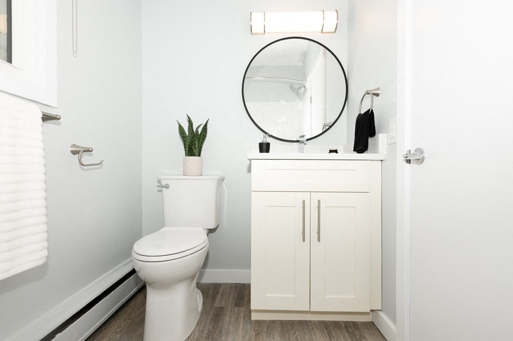 A white toilet sits next to a white cabinet in a bathroom.