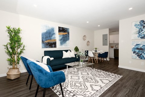 A living room with a blue chair and a white couch.