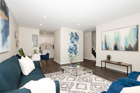 A living room with a blue couch and a white pillow.