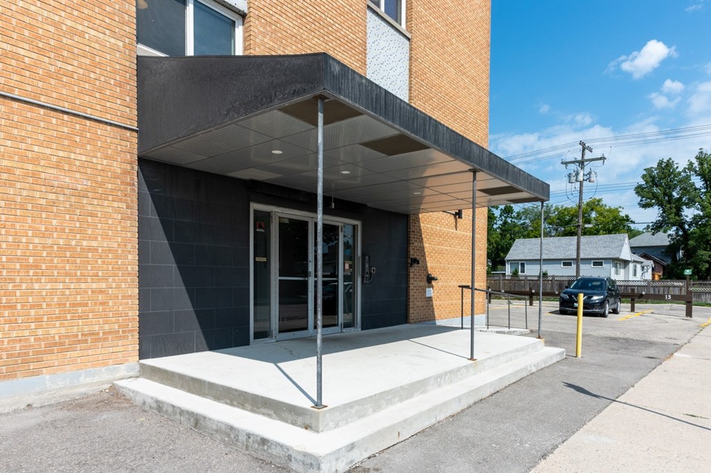 A modern building with a black awning and glass doors.