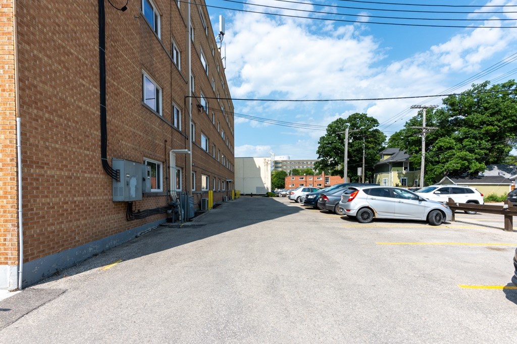 A parking lot with cars and a brick building.