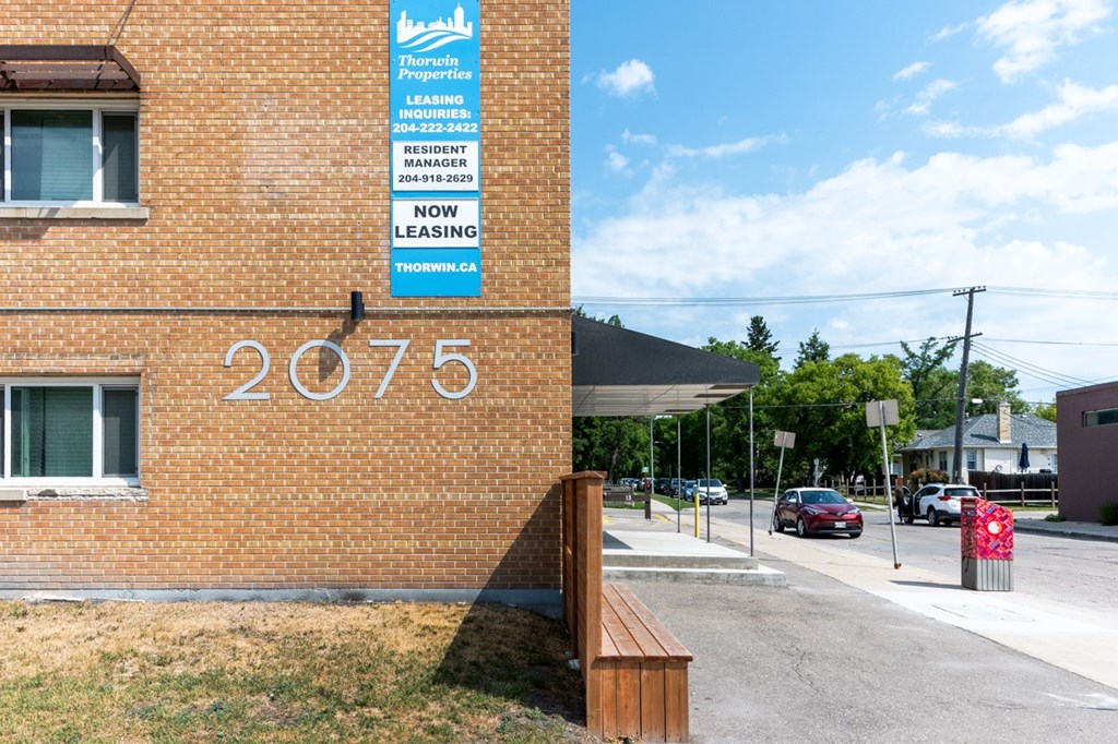 A sign for Thornton Properties is on a brick building.
