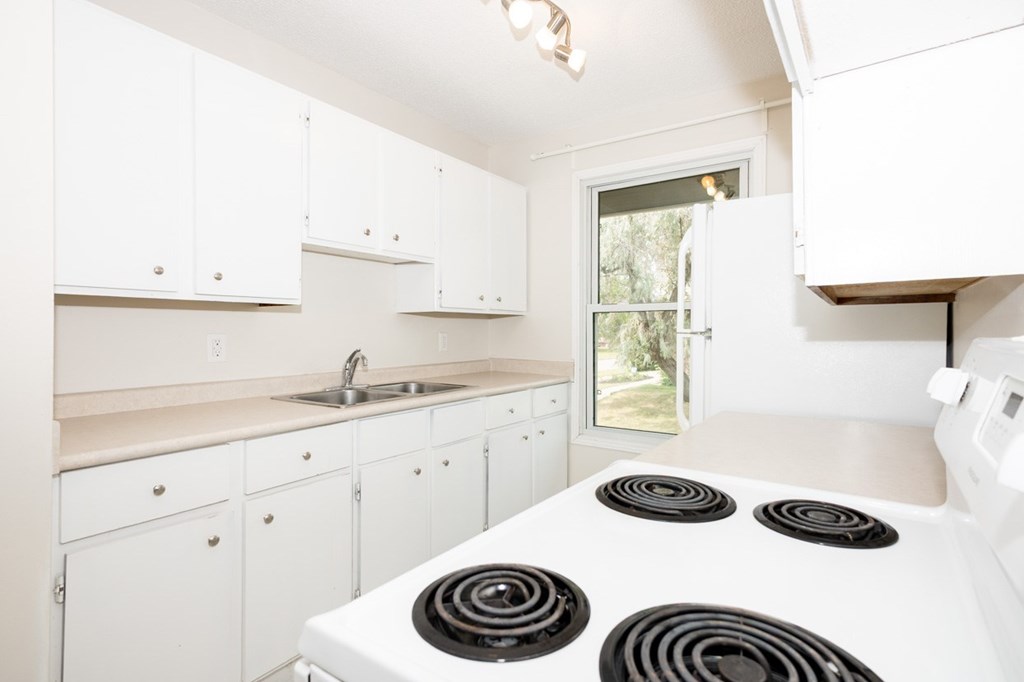 A white kitchen with a stove top oven.