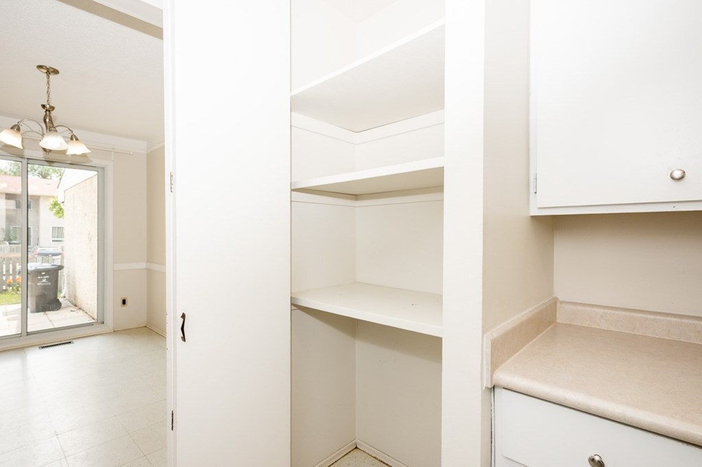 A white kitchen with a cabinet and a window.