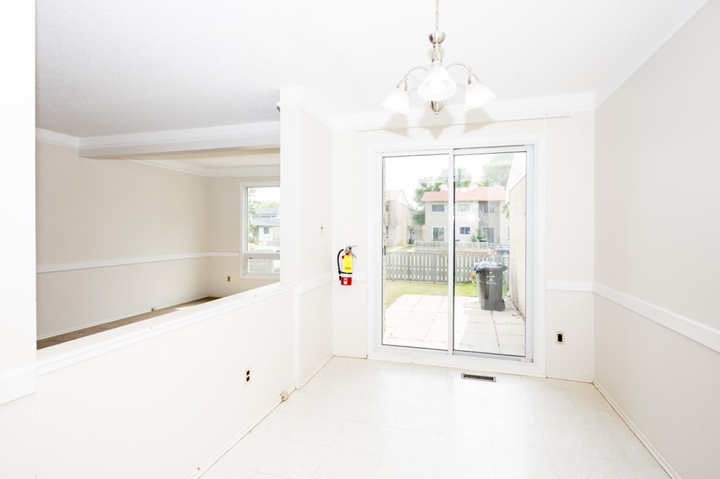 A white room with a sliding glass door leading to a balcony.
