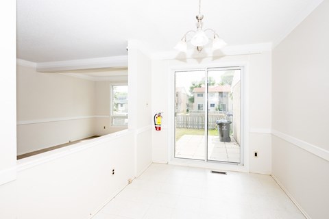 A white room with a sliding glass door leading to a balcony.