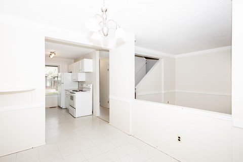 A white kitchen with a dishwasher and a refrigerator.