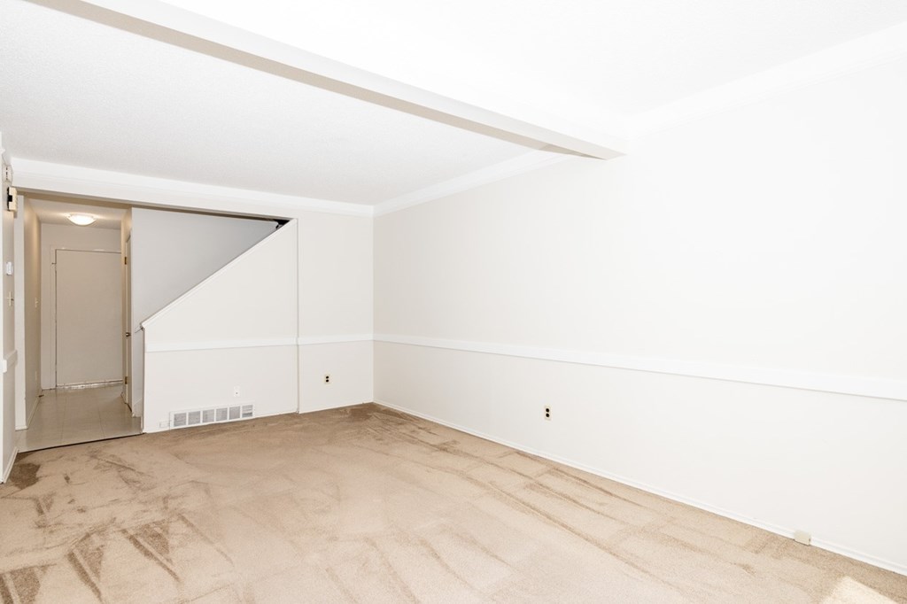 A room with a white wall and a brown floor.
