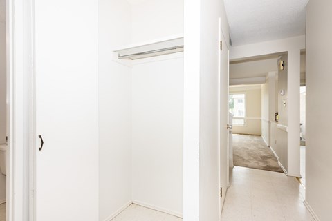 A white hallway with a door on the left and a door on the right.