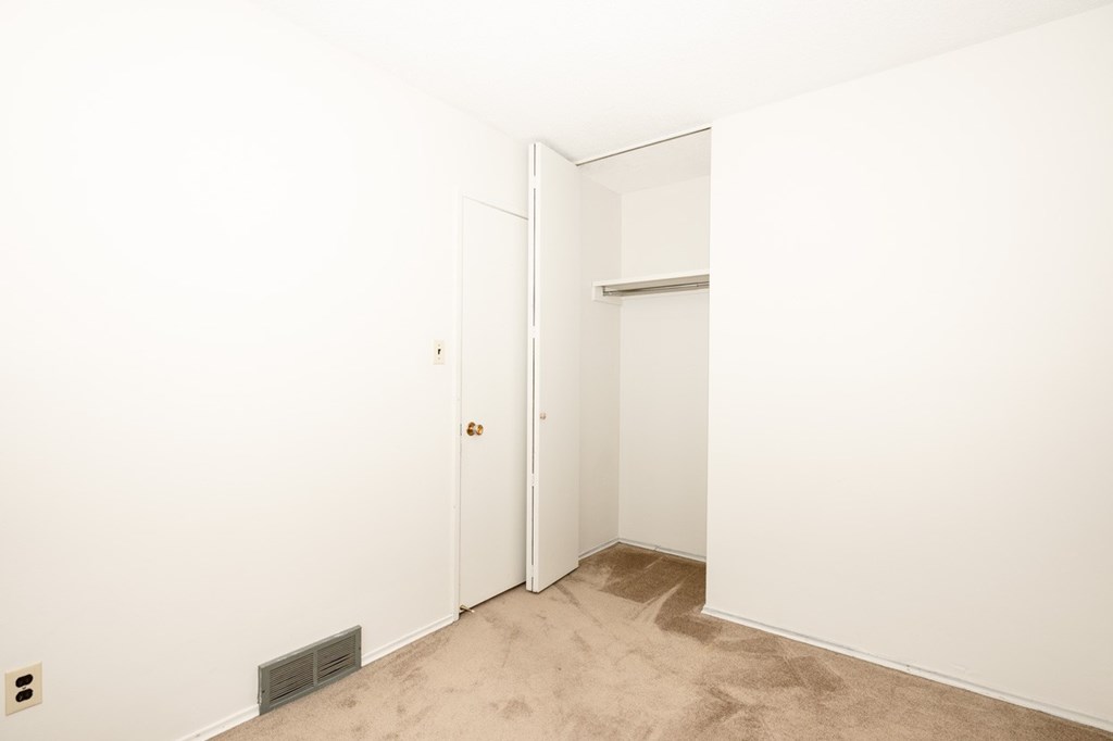 A white door is in a room with a carpeted floor.