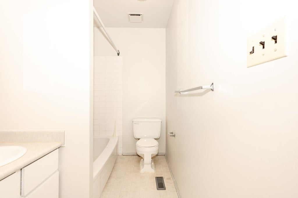 A white bathroom with a toilet, sink and bathtub.