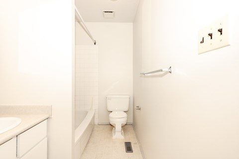 A white bathroom with a toilet, sink and bathtub.