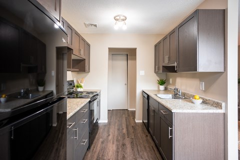 A kitchen with dark wood cabinets and a white countertop.
