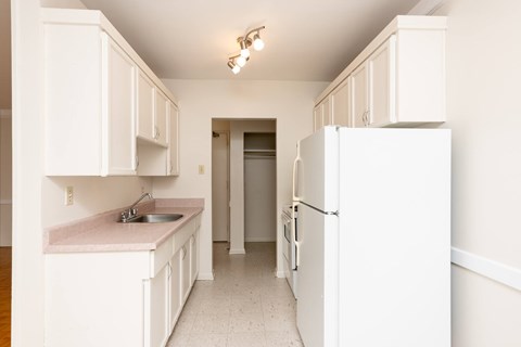 A kitchen with white cabinets and a sink.