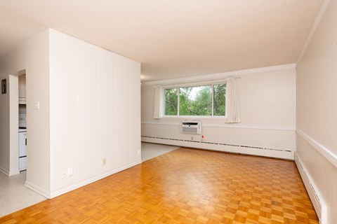 A room with a window and a wooden floor.