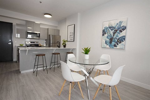 an open kitchen and dining area with a glass table and chairs