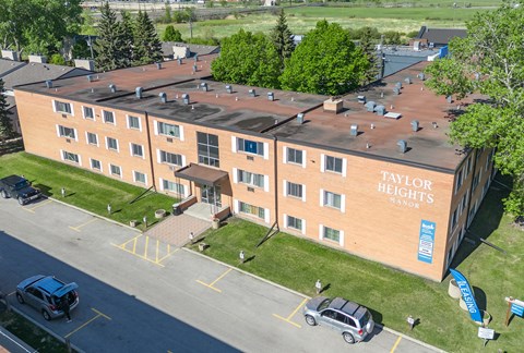 A Taylor Heights Manor building with a parking lot in front.