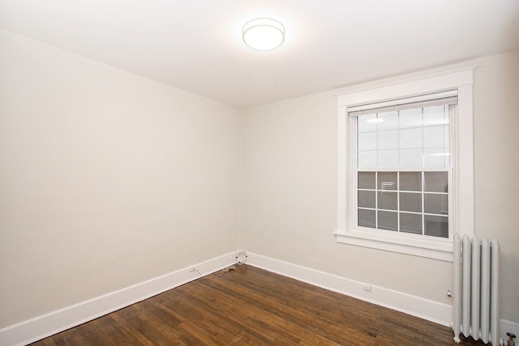 A room with a window and a radiator on the floor.