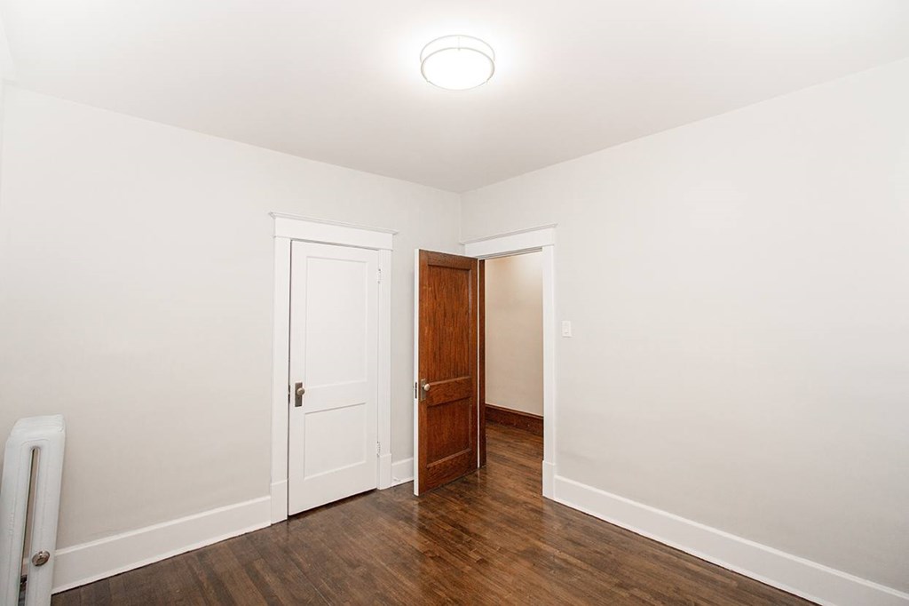 A room with a white door and a brown door.