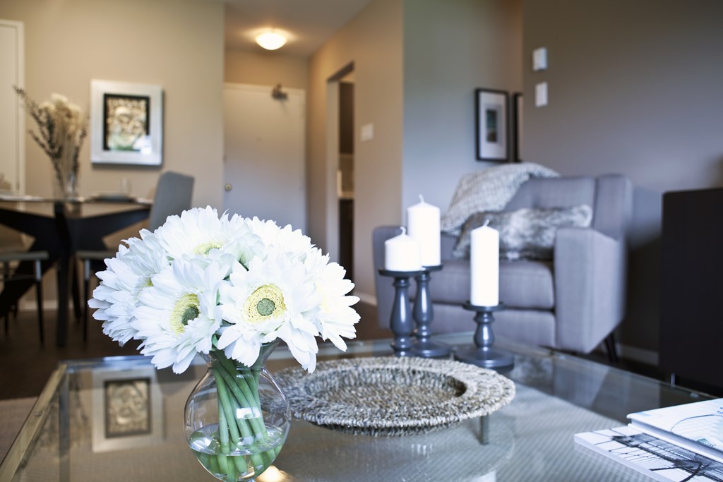 A vase of white flowers sits on a glass table.