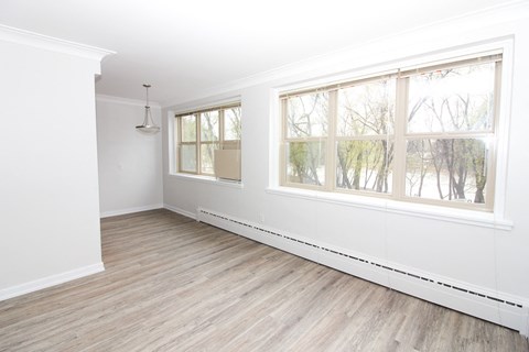 an empty living room with white walls and wood floors