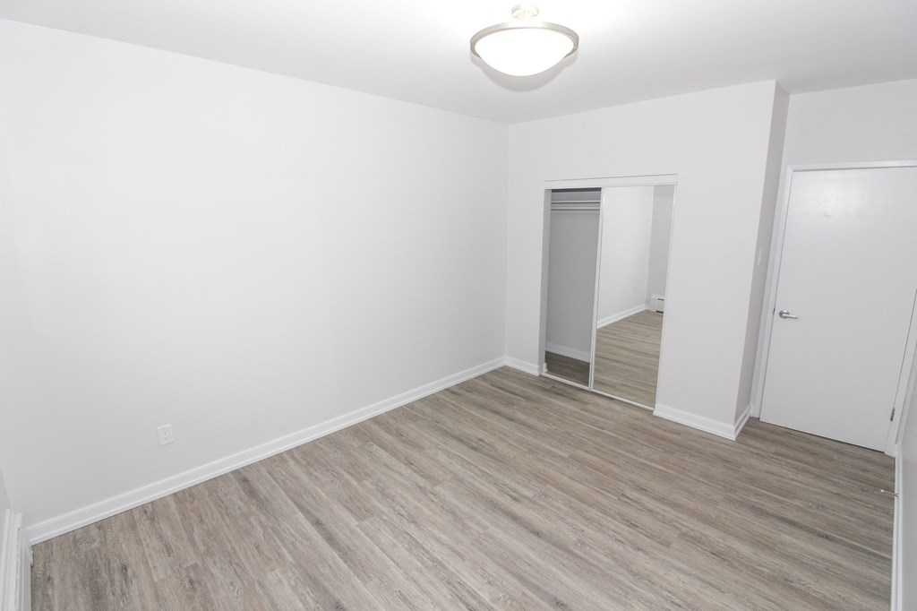 an empty room with white walls and a wooden floor