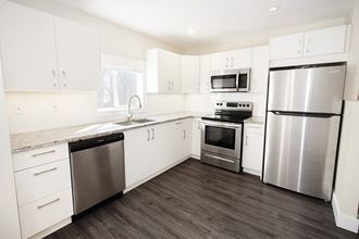 a kitchen with white cabinets and stainless steel appliances
