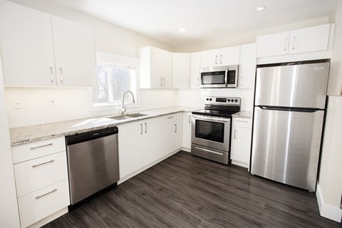 a kitchen with stainless steel appliances and white cabinets