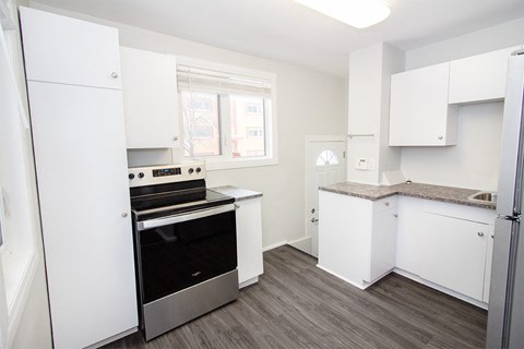 A kitchen with white cabinets and a black stove top oven.