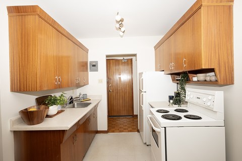A kitchen with wooden cabinets and white appliances.