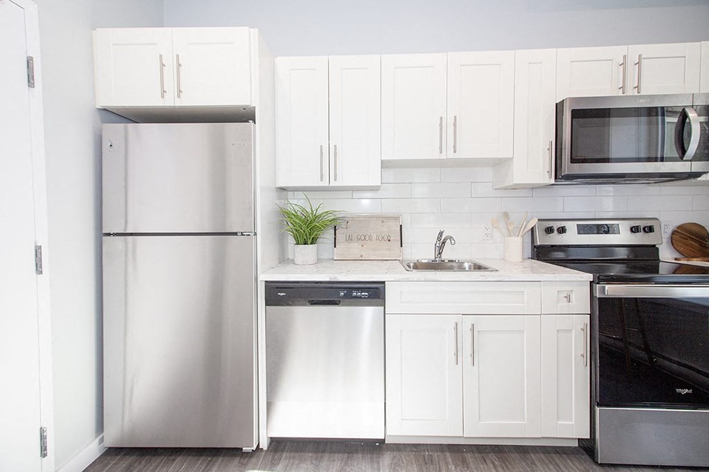 Rent in Winnipeg: a modern kitchen with white cabinets and stainless steel appliances