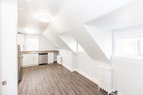 an empty kitchen with white walls and wood floors