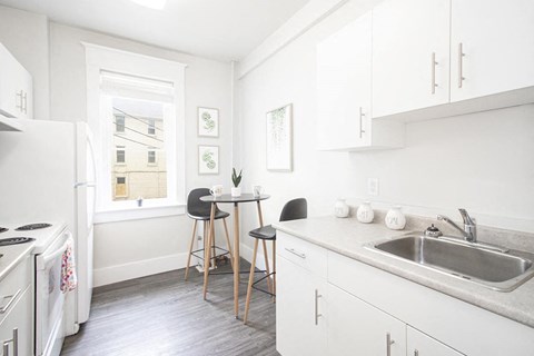 a kitchen with a sink and a table with chairs