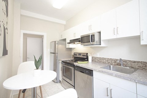 a kitchen with stainless steel appliances and a white table