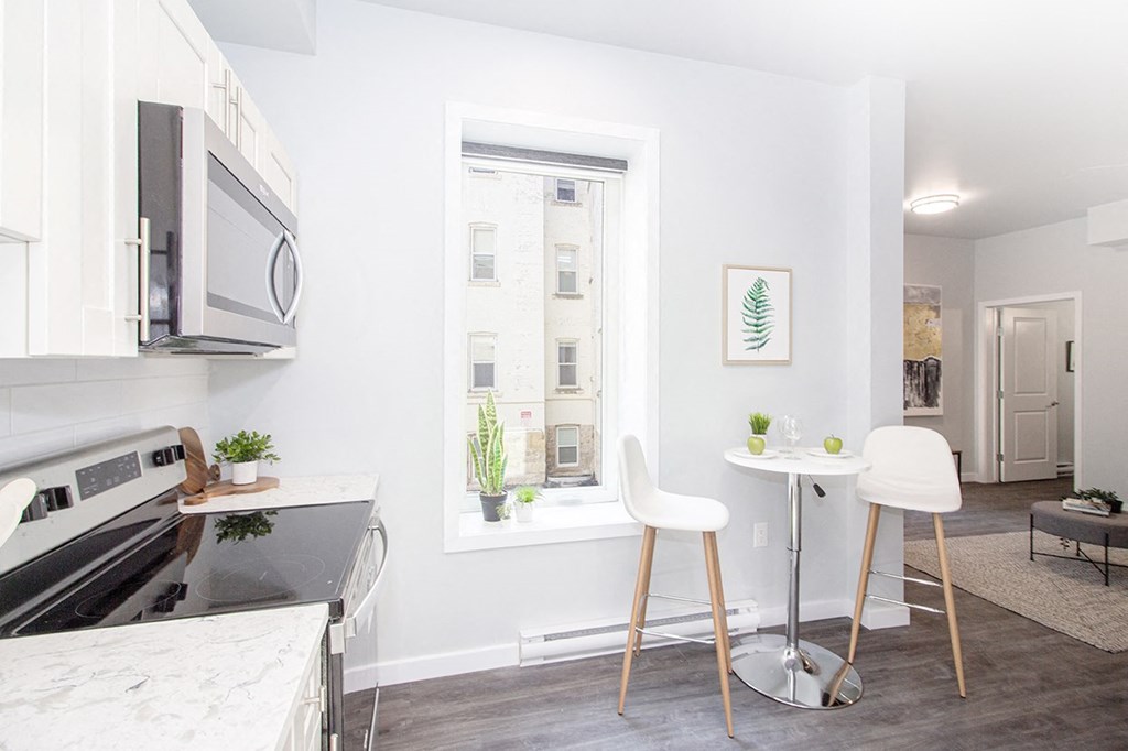 a kitchen with a small table and two chairs next to a window with a view Winnipeg