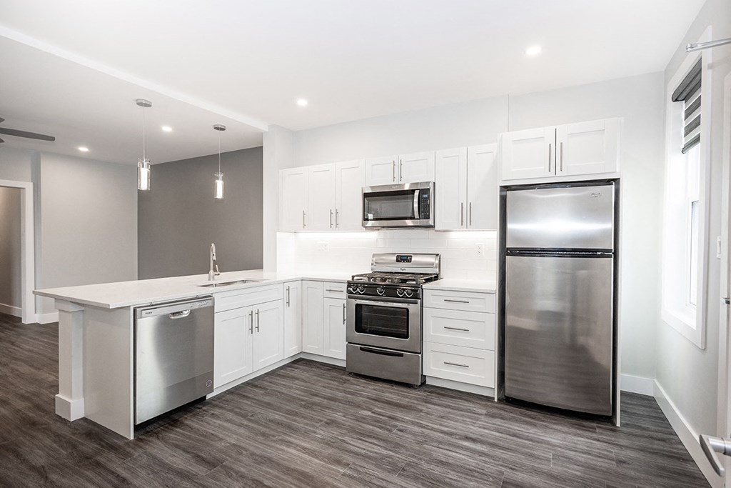 a kitchen with white cabinets and stainless steel appliances