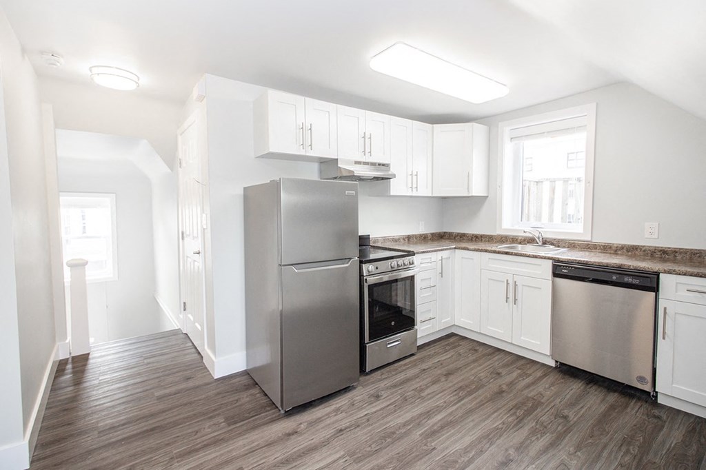 a kitchen with white cabinets and stainless steel appliances