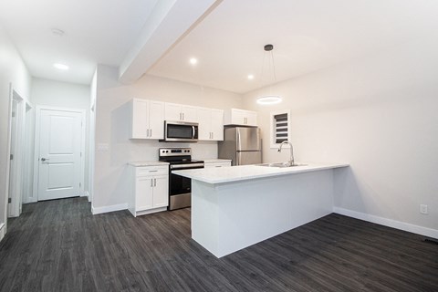 A kitchen with white cabinets and a white island.