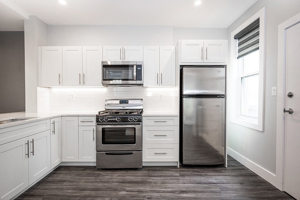 a kitchen with white cabinets and stainless steel appliances