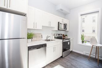 a small kitchen with white cabinets and stainless steel appliances