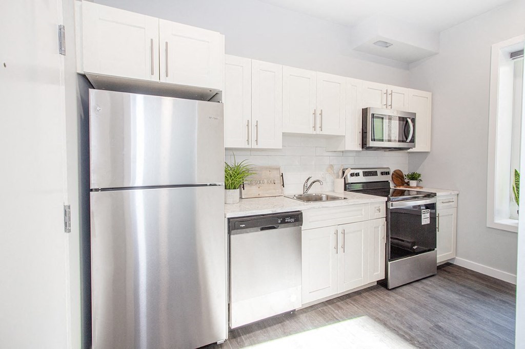 Winnipeg Apartments for rent: a renovated kitchen with white cabinets and stainless steel appliances