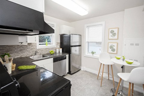a kitchen with a black counter top and a stainless steel refrigerator