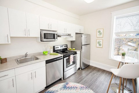 a kitchen with stainless steel appliances and white cabinets