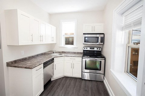 a kitchen with stainless steel appliances and white cabinets
