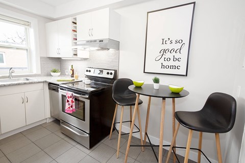 a kitchen with a small table and chairs and a stove