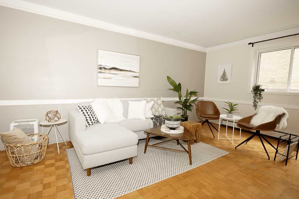 A living room with a white sofa, a wooden coffee table, and a woven basket on the floor.