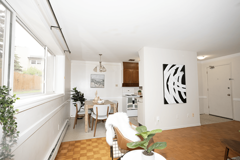 A dining room with a table and chairs.