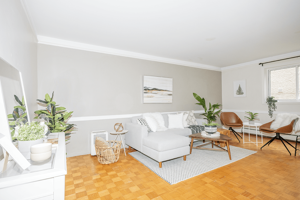 A living room with a white couch, a brown chair, and a white cabinet.
